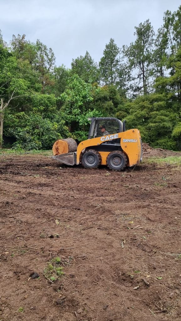 Minicargadora CASE retirando un tronco en un trabajo de alta complejidad